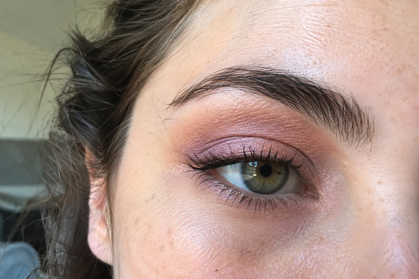 Close view of an eye with lavender and peach eyeshadow blended into the lid